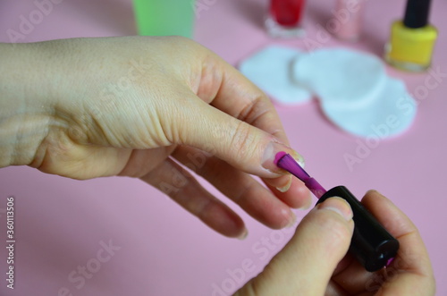 Close up image of woman using nail buffer when doing manicure  polishing nails at home. Smiling lady testing new beauty products and modern cosmetics  doing morning makeup or daily nail care routine