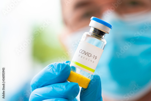 Doctor With Covid-19 Coronavirus Vaccine In Hand. Concept of research with Vaccine for Covid -19 on a research laboratory.