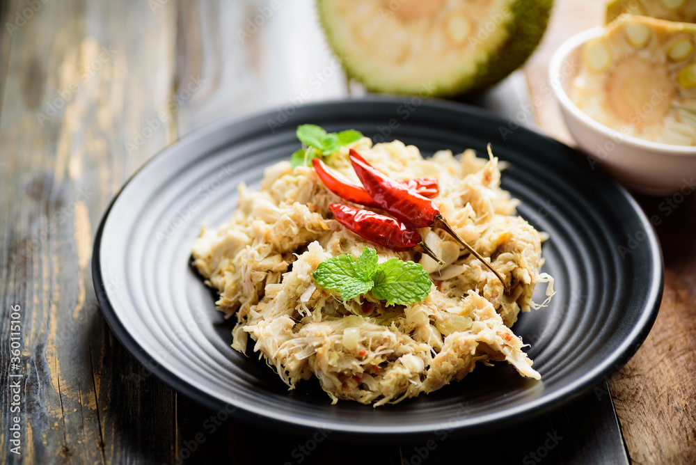 Northern Thai food (Tam Khanun), spicy pounded young jackfruit salad on black plate, Local Thai food Northern Thai food (Tam Khanun), spicy pounded young jackfruit salad on black plate, Local Thai food