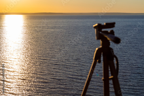 The tripod is ready to work and is mounted on top of a mountain with sea views.