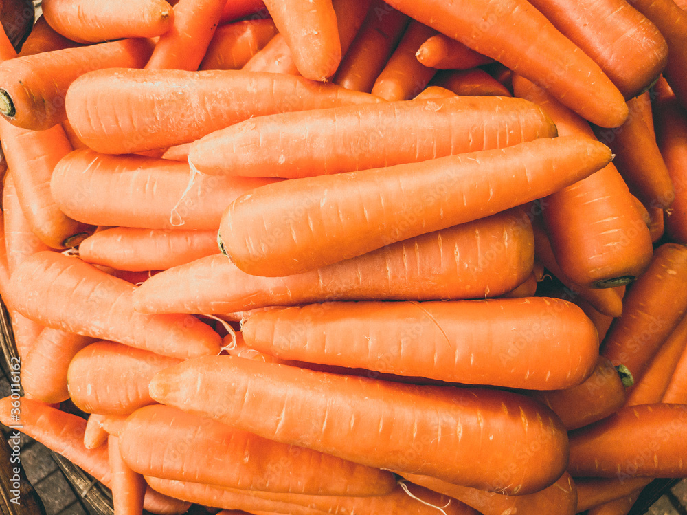 Close-up heap of carrot. Harvested young fresh organic bio raw vegetable on the market. Cooking, homemade gardening and healthy food concept, vitamins for strong immunity Close-up heap of carrot. Harvested young fresh organic bio raw vegetable on the market. Cooking, homemade gardening and healthy food concept, vitamins for strong immunity