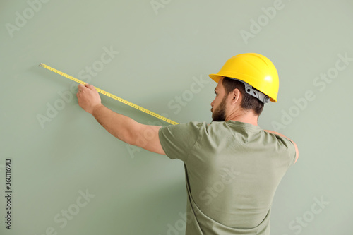 Male worker with tape measu...