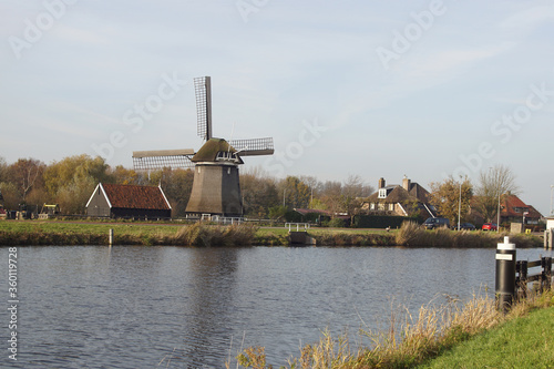 Landscape with a canal (Noordhollandsch Kanaal) and a windmill (1575) called De Sluismolen in the Netherlands. November. Village of Koedijk.