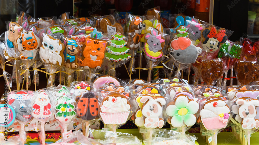 Fototapeta premium Different colorful candy canes caramel on stick. Lollipop on stick in sweets shop window.