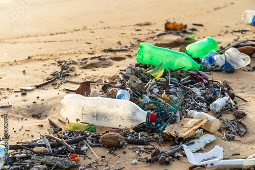 Piles of rubbish, plastic, glass bottles, wood chips and other waste strewn across the beach,