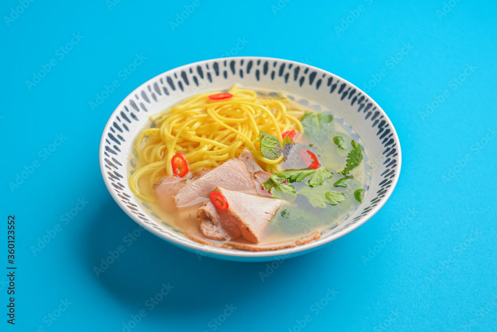 Japanese ramen soup with noodles, beef, egg, fresh parsley, sweet pepper on bright blue background. Copy space banner. Japanese ramen soup with noodles, beef, egg, fresh parsley, sweet pepper on bright blue background. Copy space banner.