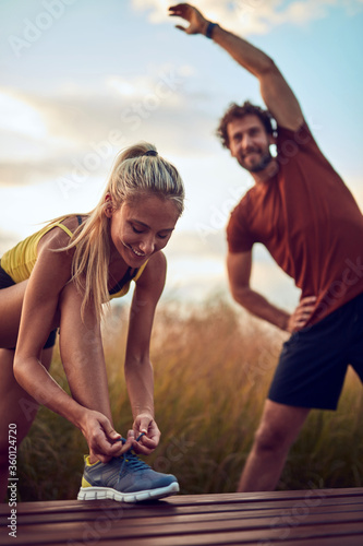 Fototapeta Naklejka Na Ścianę i Meble -  Young adult sporty couple working out outdoors.