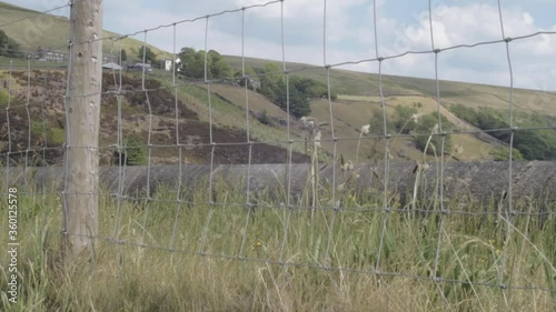 View of Yorkshire hills at Butterley reservoir wide tilting shot through fence photo