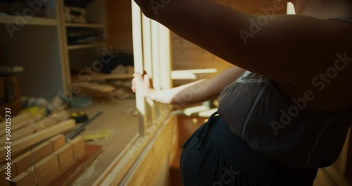 Pregnant woman building a staricase bannister in an attic room photo