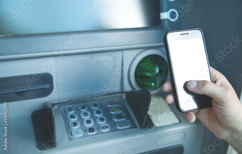 Man holding smartphone. ATM. Online transaction. Banking