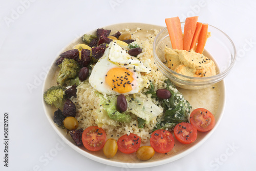 combinate dish with olives tomatoes broccoli and fried egg photo