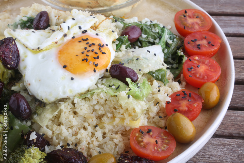 combinate dish with olives tomatoes broccoli and fried egg combinate dish with olives tomatoes broccoli and fried egg