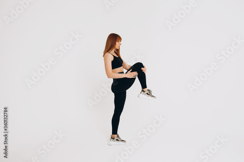 Fototapeta Naklejka Na Ścianę i Meble -  Beautiful young girl doing yoga or pilates exercise isolated on white background. Concept of healthy life and natural balance between body and mental development. Full length