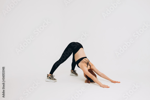 Young attractive girl practicing yoga isolated on white background. Concept of healthy life and natural balance between body and mental development. Full length © Alex