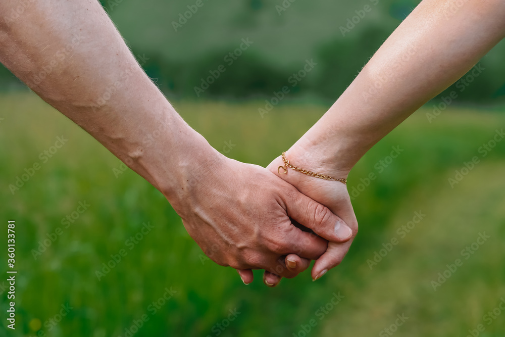 A young couple, a man and a woman holding hands, the photo symbolizes friendship and support A young couple, a man and a woman holding hands, the photo symbolizes friendship and support
