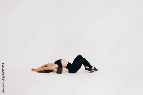 Fitness woman doing stretching workout. Full length shot of a young woman on a white background. Stretching and Motivation
