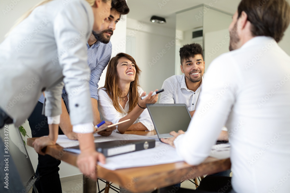 Cheerful coworkers in office during company meeting Cheerful coworkers in office during company meeting
