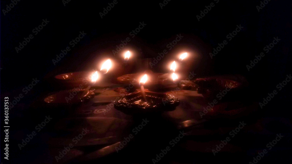 Lighting diyas(lamps) on black background during Diwali.