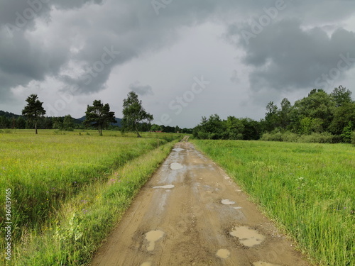 Poland Low Beskids Wysowa Zdroj. Stormy clouds over a country road.