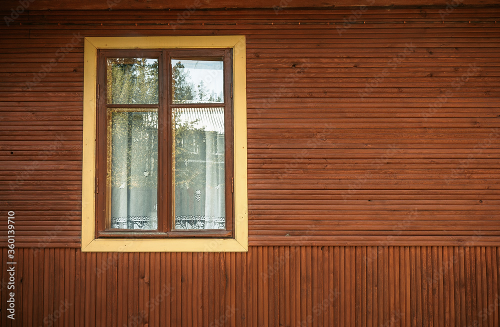 Yellow window in a wooden house Yellow window in a wooden house