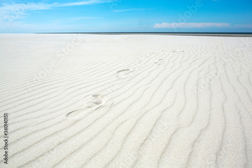 Calm day on abandoned white sand beach.