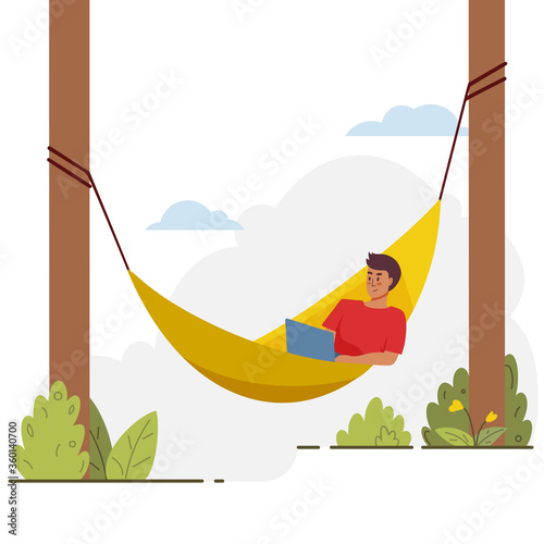 Young male lies with laptop on hammock