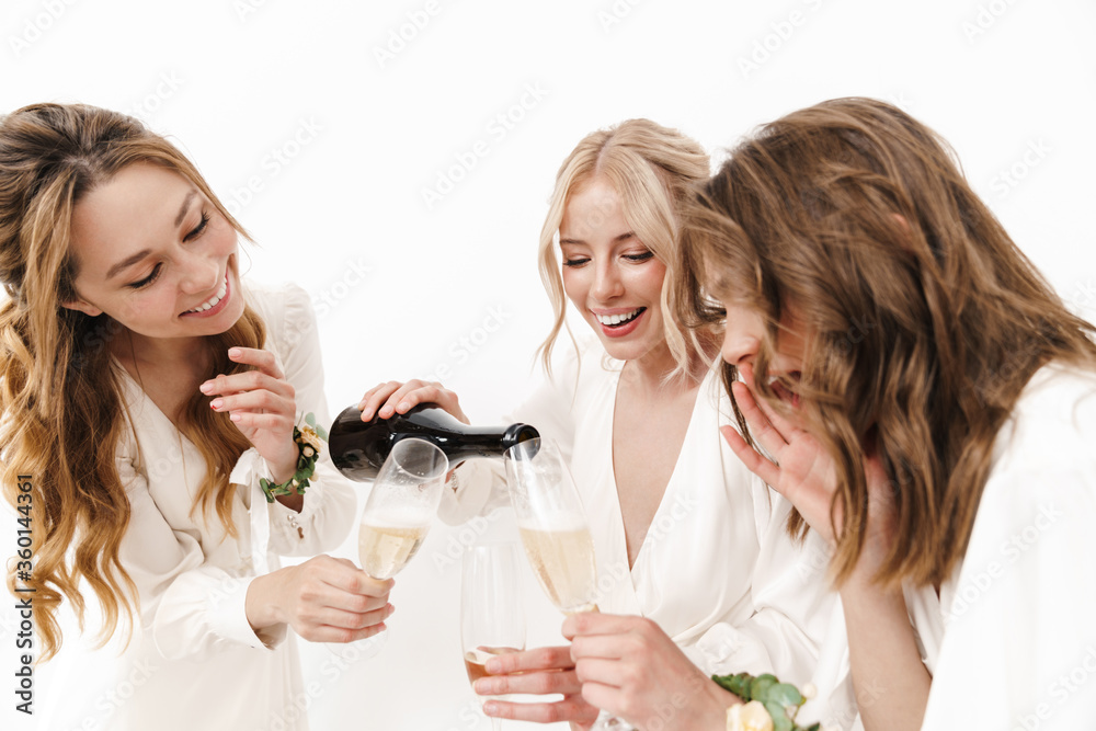 Photo of bride with her bridesmaids laughing and drinking champagne Photo of bride with her bridesmaids laughing and drinking champagne