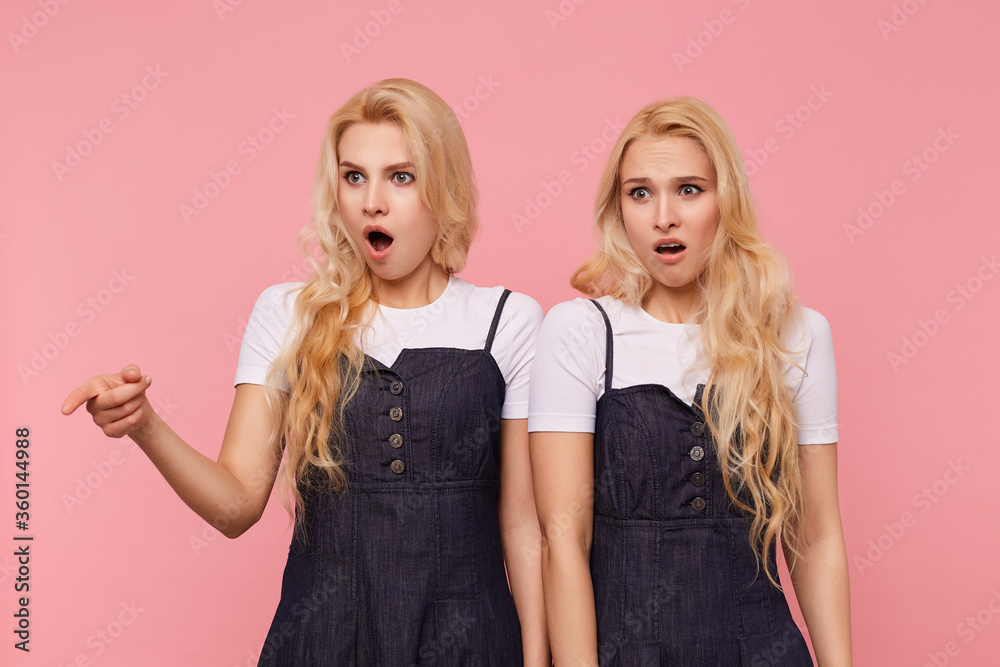 Horizontal shot of young bewildered long haired white-headed females keeping their mouths opened while looking confusedly aside, isolated over pink background Horizontal shot of young bewildered long haired white-headed females keeping their mouths opened while looking confusedly aside, isolated over pink background