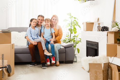 Happy family with cardboard boxes in new house at moving day.