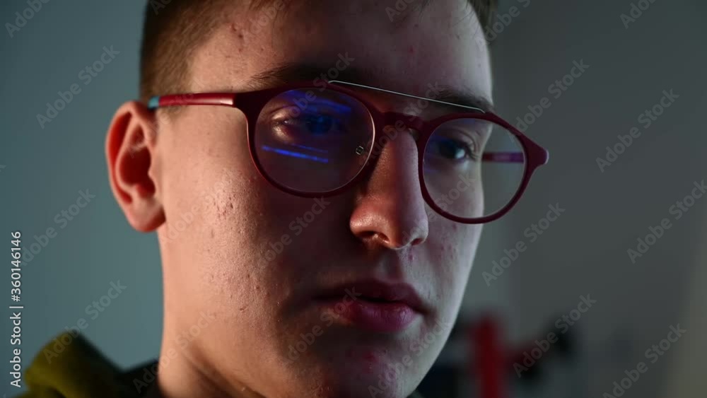 Young male programmer working at laptop wearing protection glasses Young male programmer working at laptop wearing protection glasses