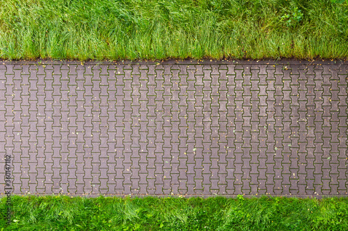 Straight line of stone pavement and lawn on both sides. Top view 