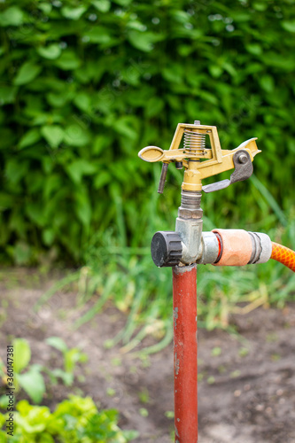 Old rusty water pump / sprinkler in the garden