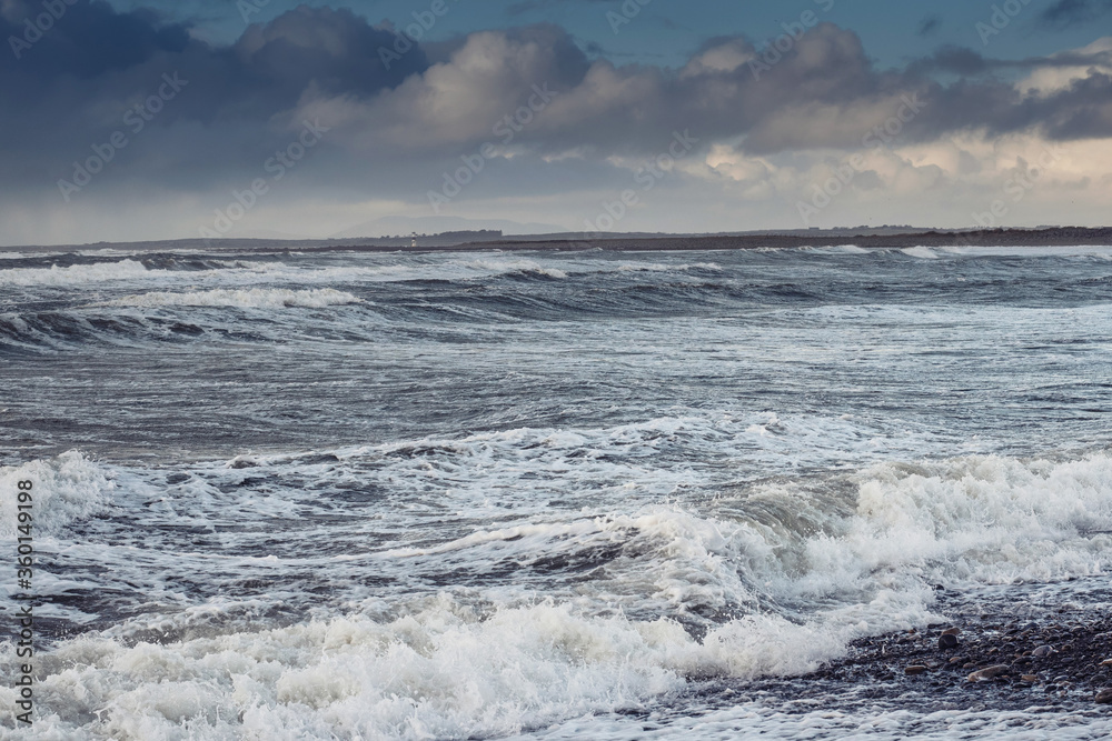 Powerful waves in the ocean. Strandill town, County Sligo, Ireland. west coast, Nobody, Blue cloudy sky. Cool tones.