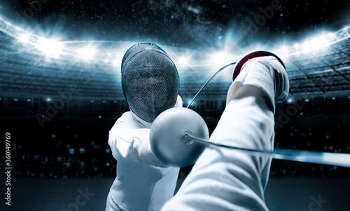 Portrait of two fencers against the backdrop of a sports arena. The concept of fencing. Duel. photo