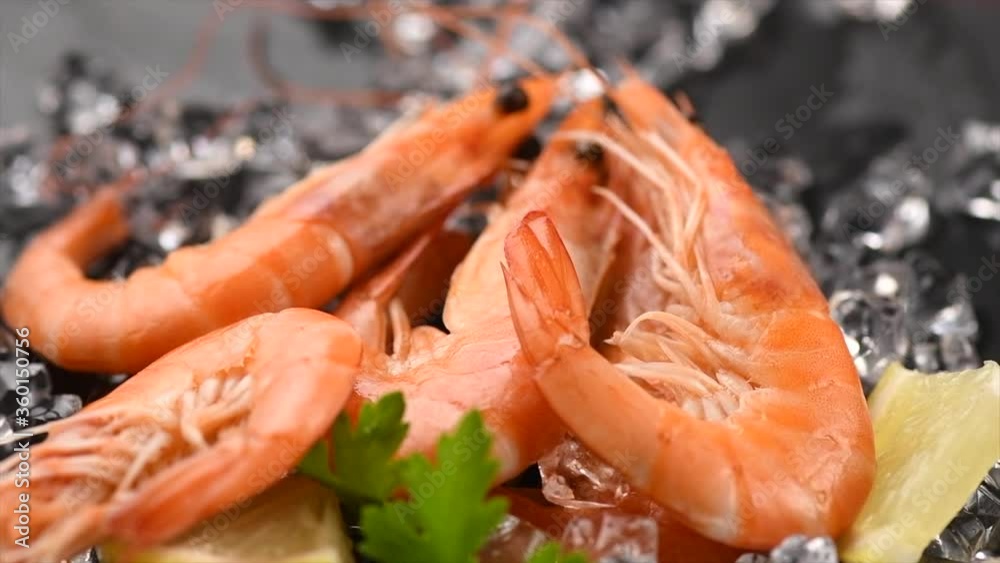 Shrimps, prawn. Fresh Prawn on crushed ice, served with lemon rotating on Black Background. Seafood, preparing healthy gourmet food, healthy eating, cooking, diet, nutrition concept. Slow motion 4K. Shrimps, prawn. Fresh Prawn on crushed ice, served with lemon rotating on Black Background. Seafood, preparing healthy gourmet food, healthy eating, cooking, diet, nutrition concept. Slow motion 4K.