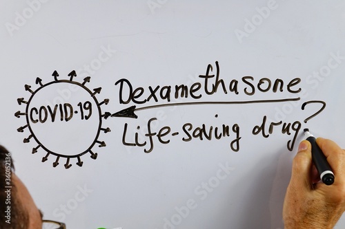 Lecturer gives an idea of ​​the effect of the drug dexamethasone on Covid-19 on a white board photo