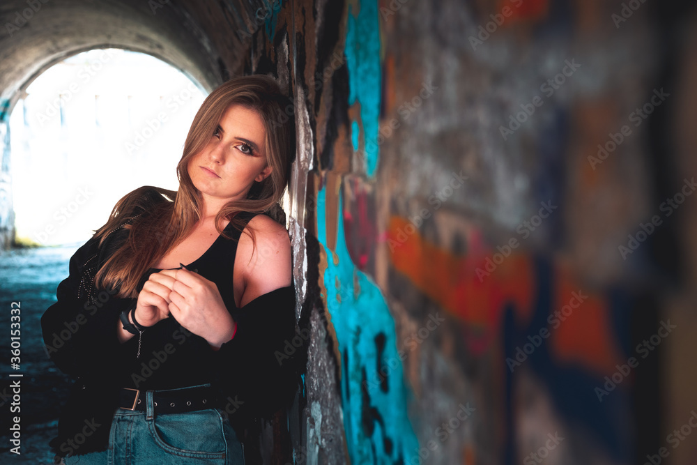 Naklejka premium Beautiful young girl posing inside a tunnel in an old fortificacion actually in ruins.