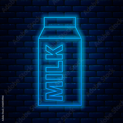 Glowing neon line Paper package for milk icon isolated on brick wall background. Milk packet sign. Vector.