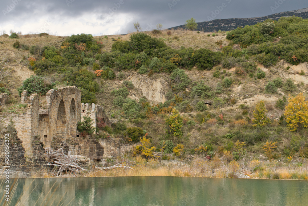 Ruines d'un ancien pont sur une rivière en Espagne, à son pied un amas de troncs et de branchages, témoignage d'une crue abondante du cours d'eau