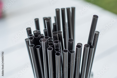 Macro photo drink straw. Stock photo black plastic drink straws