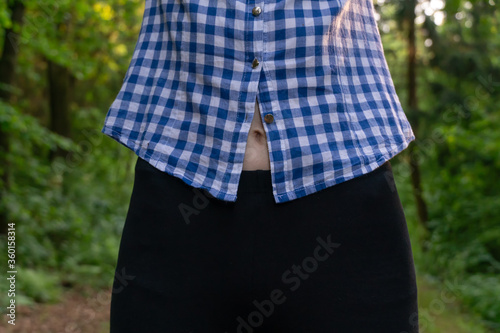 Obraz na plátne navel of a young slender woman after a workout is visible through the shirt