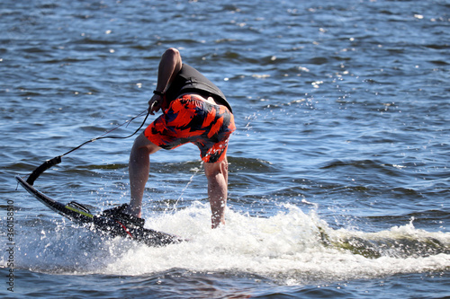 Jet surfing on a water, man riding on jet surfboard. Surfer on the sea, summer sport