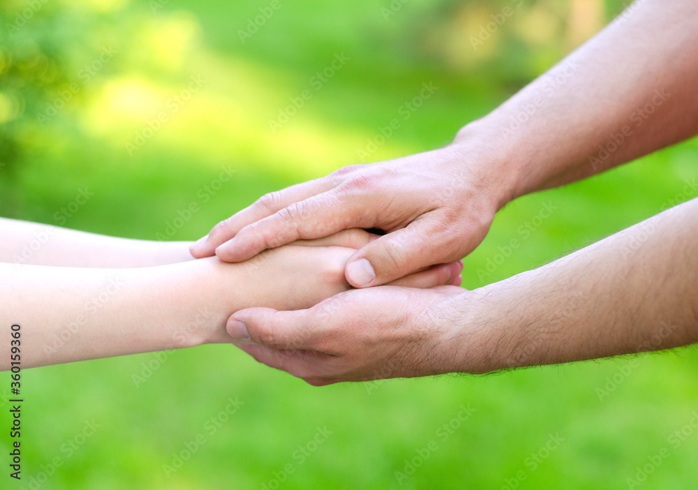 Father male hands holding child hands Father male hands holding child hands