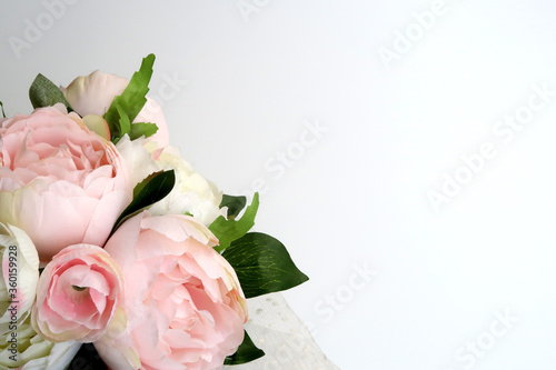 Green leaves with pink and white flowers on white background.