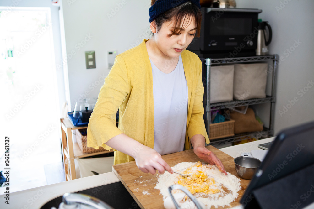 小麦粉と卵を混ぜる、料理中の女性 小麦粉と卵を混ぜる、料理中の女性