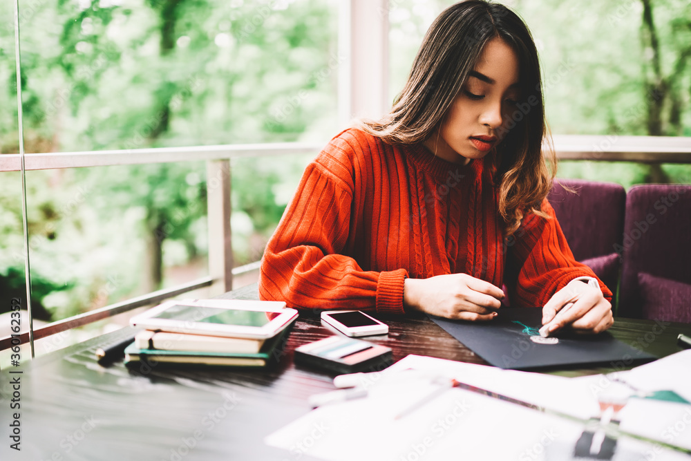 Creative young female artist working on drawings and sketches sitting at comfortable working place, talented asian hipster girl enjoying art spending time on hobby using stationery and equipment