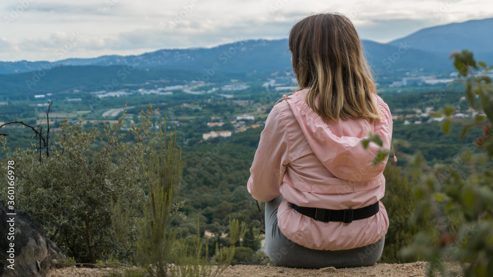 a girl athlete resting sitting on top of a mountain