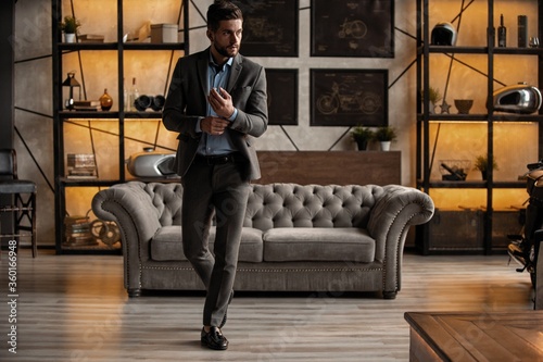 Obraz na plátne Full length of handsome young man looking away and keeping hands in pockets whil