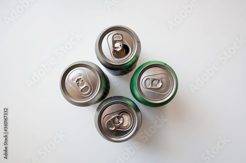 Four metal drink cans isolated on white background from a high angle view