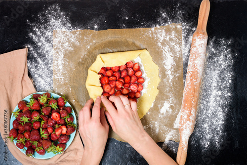 step by step recipe the process of making galetta with strawberries at home, top view on a dark background, ingredients for strawberry pie
